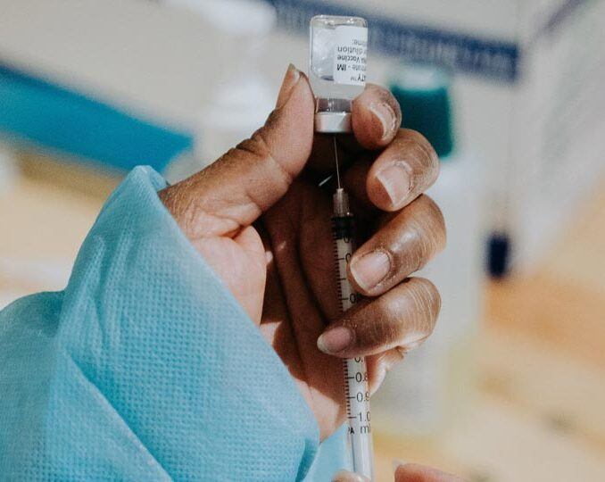 A healthcare worker preparing to administer a COVID-19 vaccine.