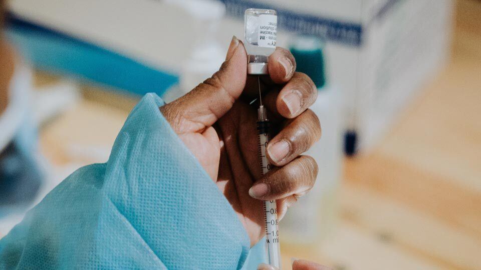 A healthcare worker preparing to administer a COVID-19 vaccine.