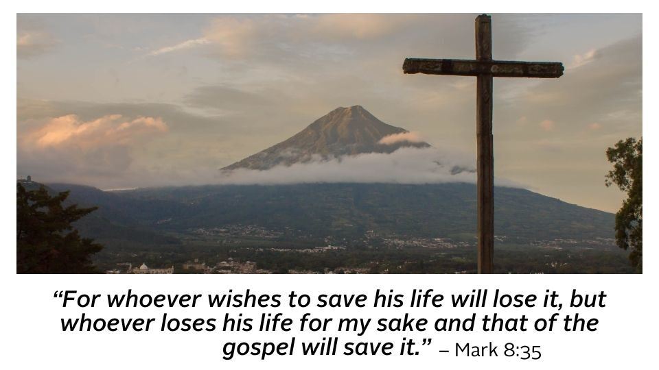 cross overlooking a mountaintop with bible scripture below