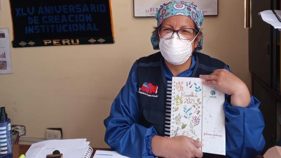 A community health worker holding a mental health training booklet in Peru.