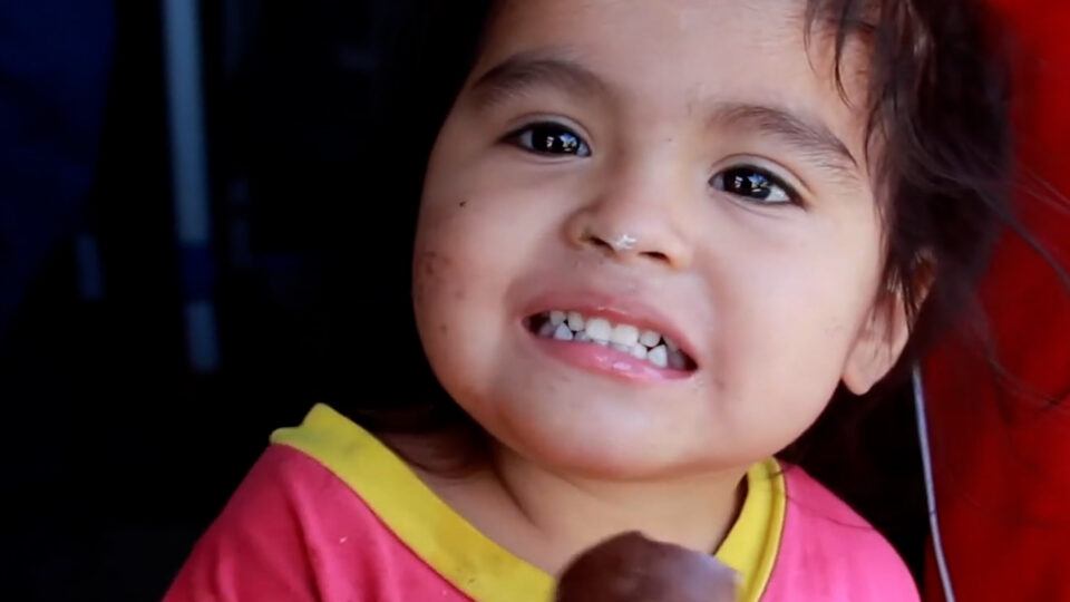 Small Girl in Peru Smiling and Eating