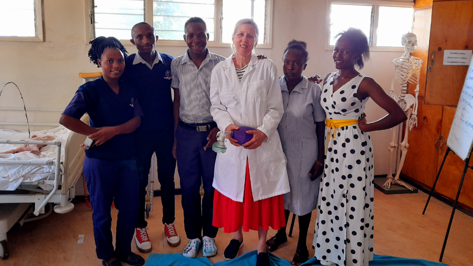 Susan S, CMMB Volunteer, stands with her students in Kenya