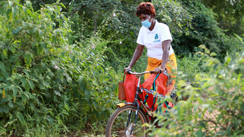 Elizabeth rides her bike to deliver life-saving care to families in need as a CMMB-supported community health worker