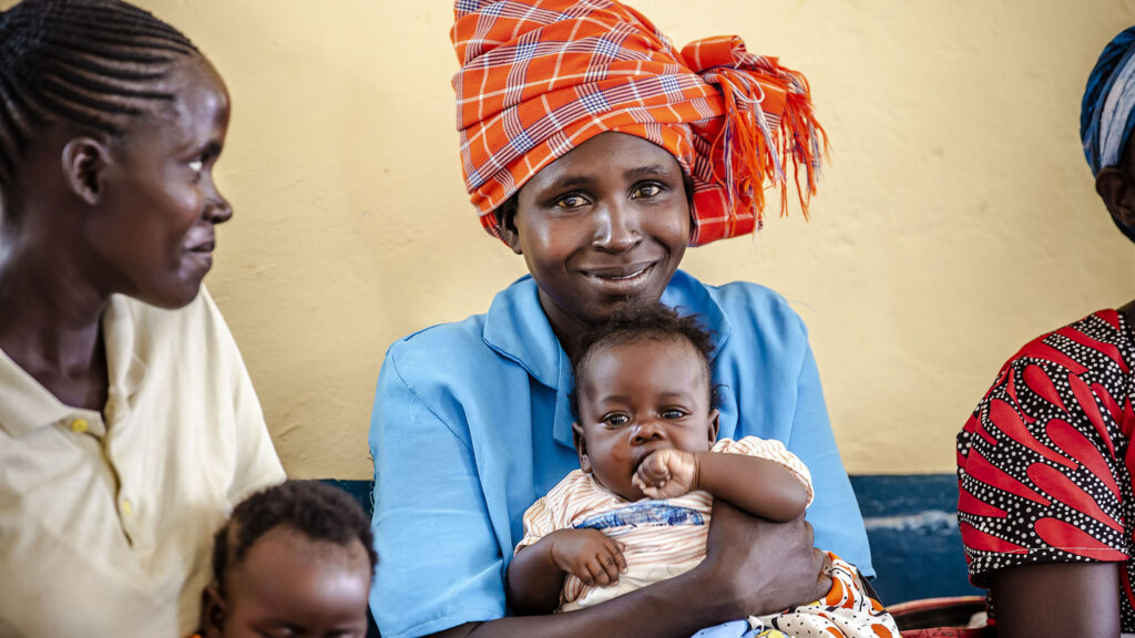 A mom holds her baby and smiles at the new maternity ward in Kenya_June2022