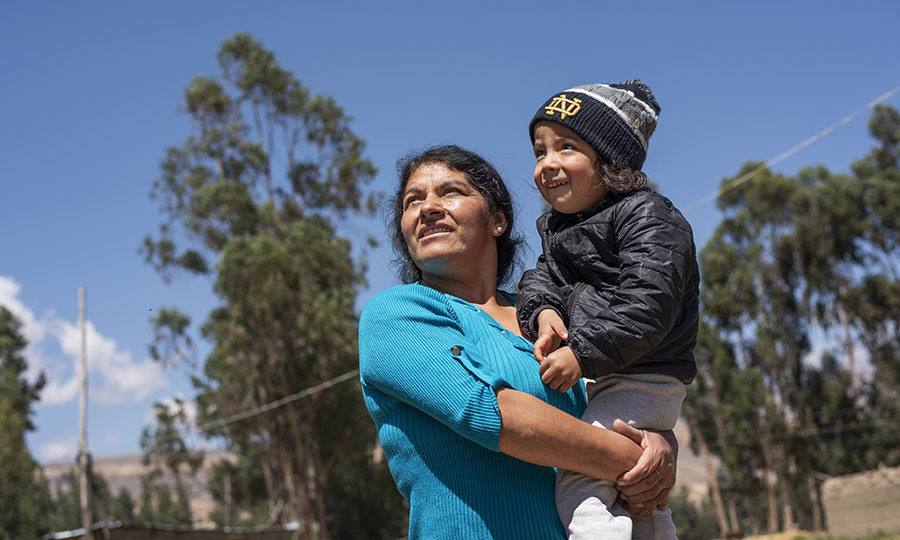 Community health worker Angelica holds her son in Peru Nov2022. Like Raquel, featured in this story, Angelica supports the women and their families with nutrition knowledge.
