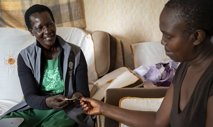 Community health promoter provides malaria medication to a young woman.