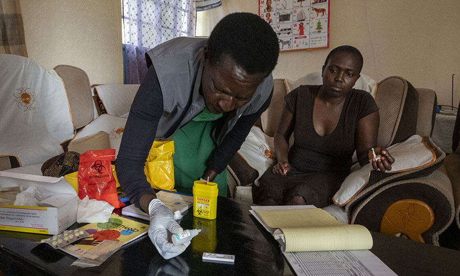 A community health promoter administers a malaria test.