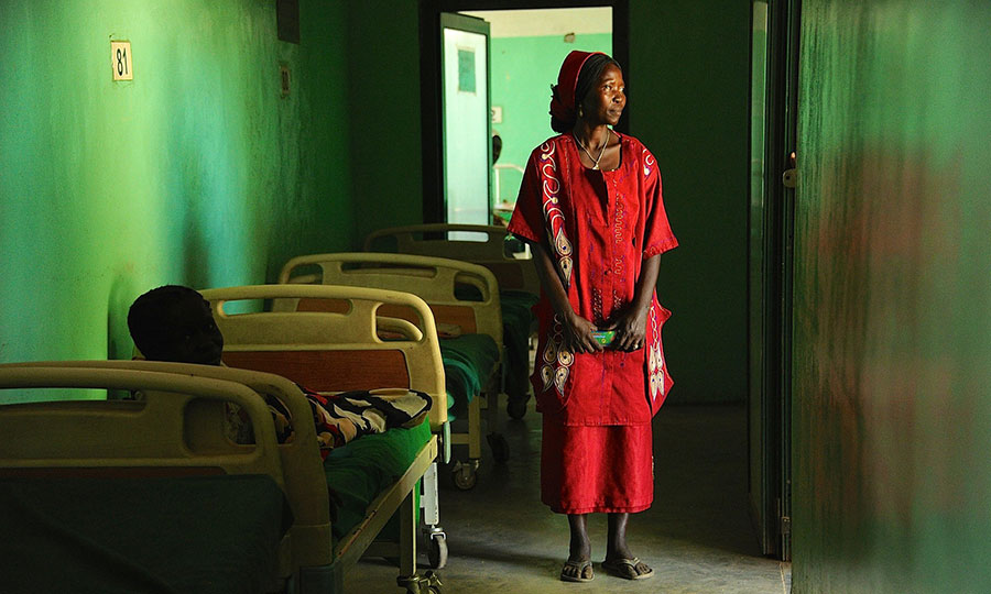 A woman stands in a darkened hallway of the Mother of Mercy Hospital in South Sudan.