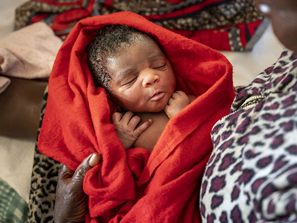 A-newborn-baby-wrapped-in-a-red-blanket-in-South-Sudan A newborn baby is wrapped in a red blanket. She receives access to trusted medical care thanks to the support of CMMB donors.
