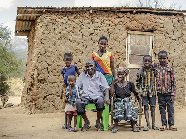 A family stands in front of their home in Kenya.