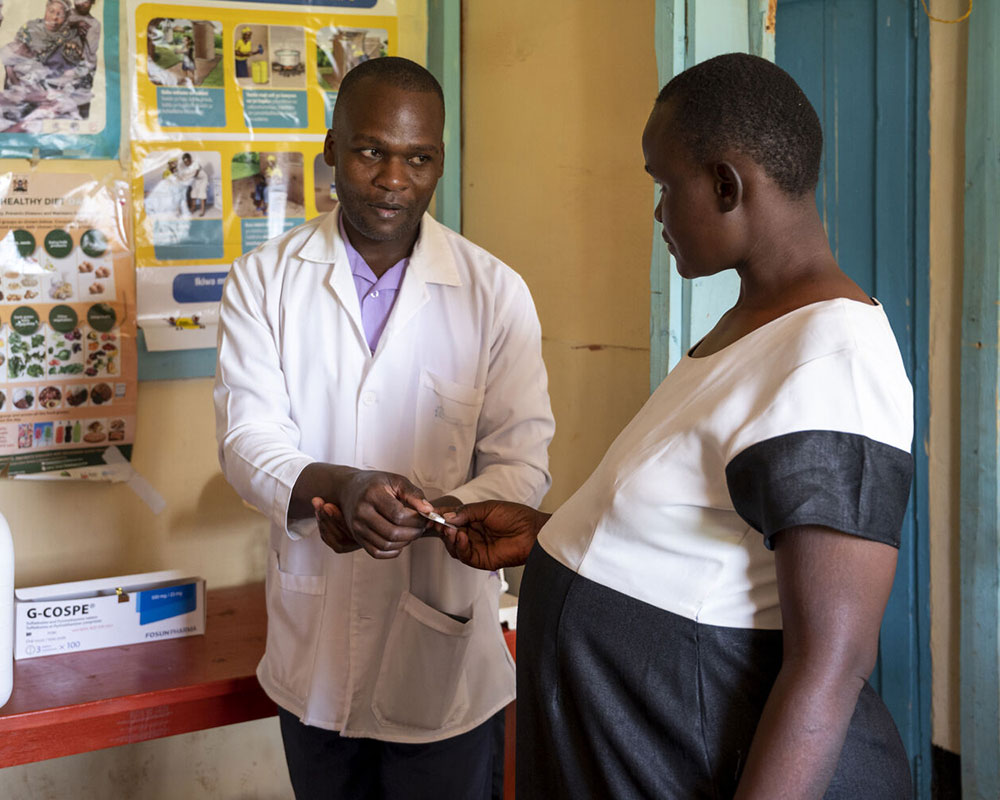 _Filling-Gaps-in-Low-Resource-Countries-KE-2023 A health worker provides medications to a pregnant woman at a rural health facility in Kenya.