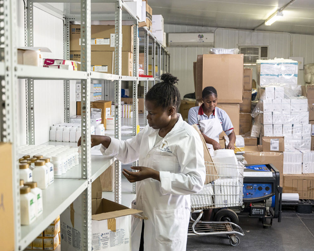 NCDI-Initiative-featured-image-ZA-2023 A pharmacist organizes the shelves of her phramacy.