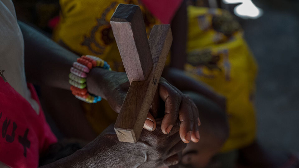 Hands-clasped-around-wooden-cross-South-Sudan Hands clasped around a wooden cross during church in South Sudan. In this blog we share an update on the South Sudan conflict.