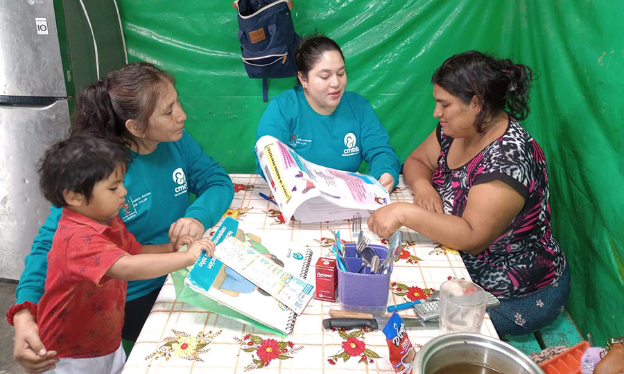 Veronica nad her son speak with a CMMB-supported community health worker