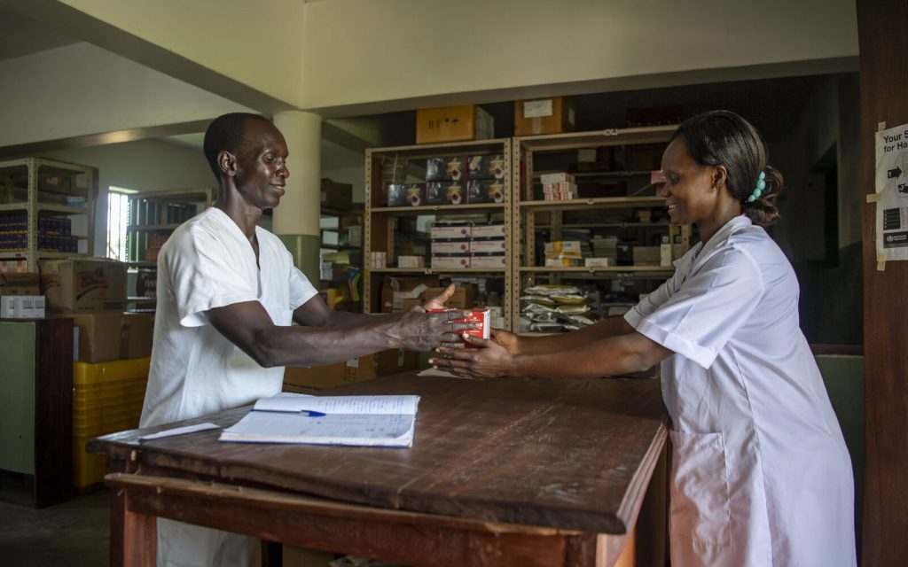 A nurse and a pharmacist hand off medicine. 