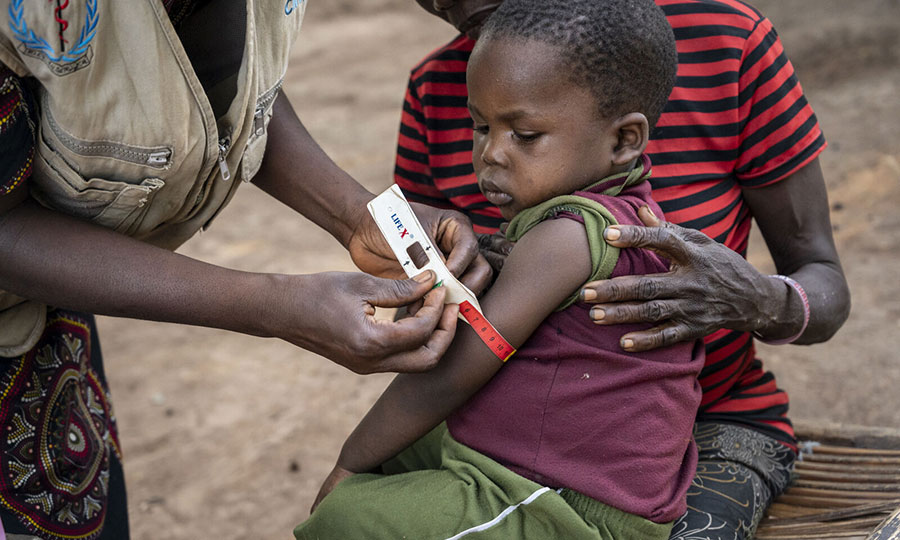 MUAC-band-measurement-CMMB-South-Sudan A CHW in South Sudan checks a child for malnutrition with a MUAC band.