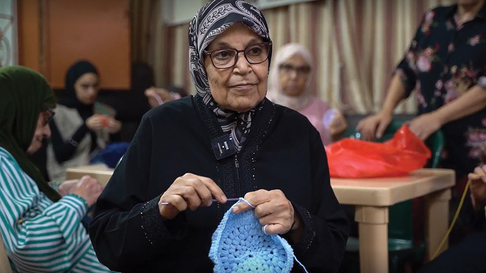 Um Samer crochets using her new glasses.