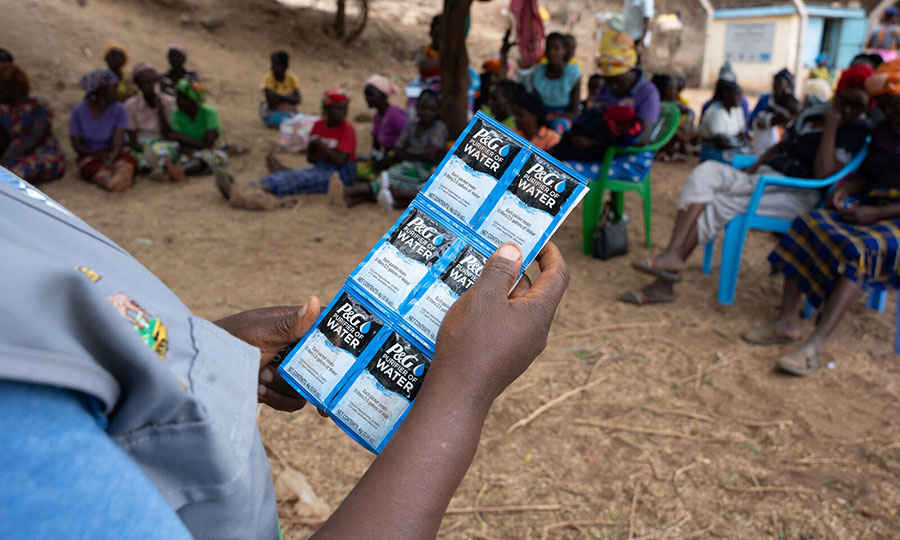 A community health promoter demonstrates how to use the P&G Purifier of Water Sachets.