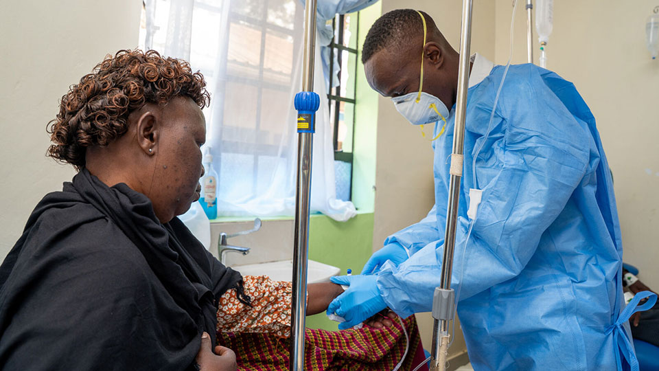 A clinician at Kitui County's Cancer Center administers a patient's medication.