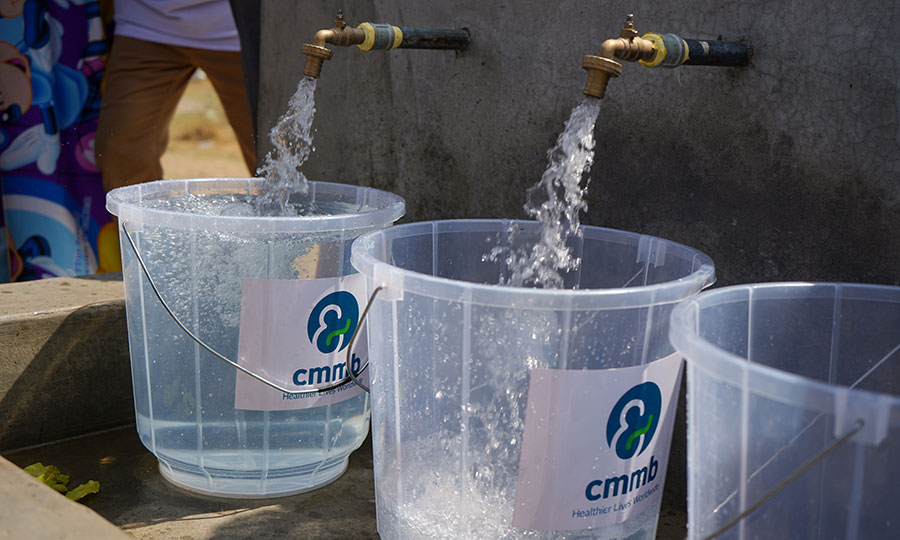 Clean water pours into buckets thanks to the new water yard installed by CMMB.