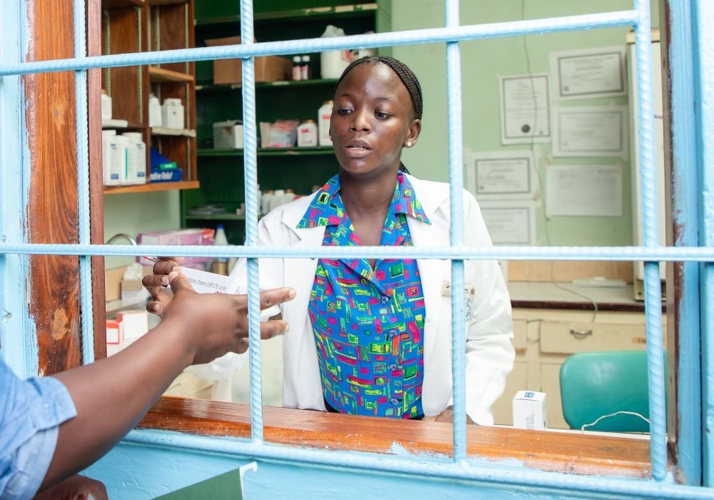 a pharmacist looks at a script from a patient